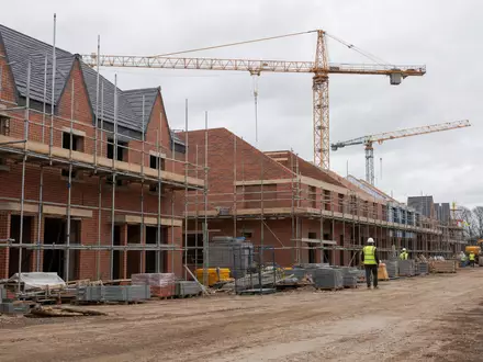 Vistry Group PLC GB0009692319 zeigt fotorealistische Baustelle mit Kränen für neue Wohnhäuser England - Foto: THN