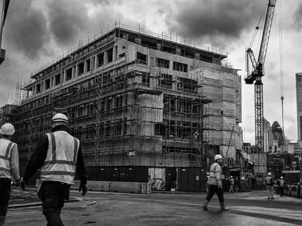 Schwarzweiß-Reportagefoto von Baustelle und Bürofassaden dokumentiert aktuelle Derwent London plc GB0002652740 Regenerierungsprojekte in London - Foto: THN