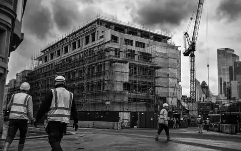 Schwarzweiß-Reportagefoto von Baustelle und Bürofassaden dokumentiert aktuelle Derwent London plc GB0002652740 Regenerierungsprojekte in London - Foto: THN