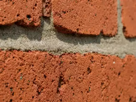 Bellway p.l.c. (GB0000904986) zeigt eine Makroaufnahme roter Ziegelsteine, typisches Baumaterial der britischen Baubranche - Foto: THN