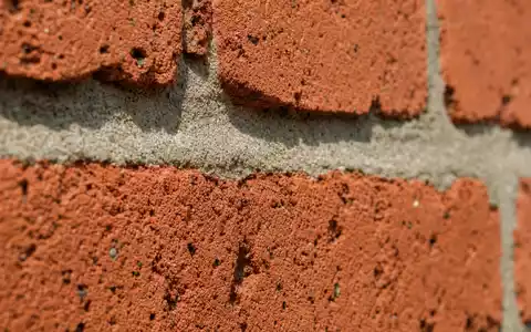 Bellway p.l.c. (GB0000904986) zeigt eine Makroaufnahme roter Ziegelsteine, typisches Baumaterial der britischen Baubranche - Foto: THN
