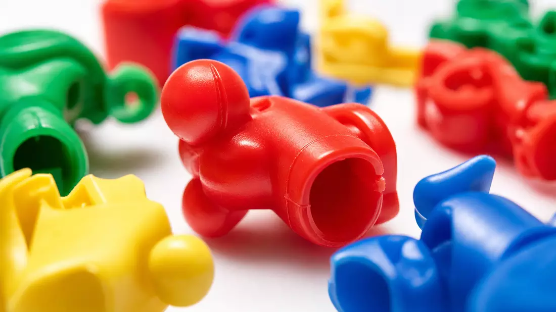 Extreme Nahaufnahme bunter Plastik-Spielzeugkomponenten von Hasbro Inc. in Rot Gelb Grün Blau