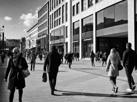 Hamborner REIT DE0006013006 – Schwarz-Weiß-Reportage einer deutschen Einkaufsstraße mit Passanten und Gewerbeimmobilien - Foto: THN