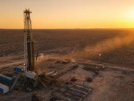 Halliburton Aktie US4062161017 zeigt fotorealistische Bohrinsel bei Sonnenuntergang in der Wüste mit Arbeitern - Foto: THN