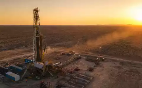 Halliburton Aktie US4062161017 zeigt fotorealistische Bohrinsel bei Sonnenuntergang in der Wüste mit Arbeitern - Foto: THN