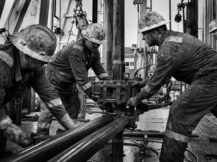 Halliburton US4062161017 Schwarz Weiß Reportage von Bohrarbeitern beim Bedienen schwerer Anlagen auf dem Rig - Foto: THN