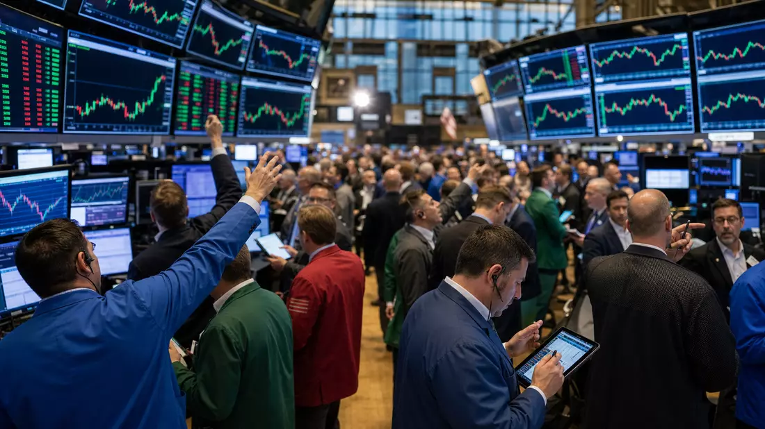 Redaktionsfoto des NYSE-Handelssaals mit Tradern und Energiesektor-Kurscharts auf großen Screens