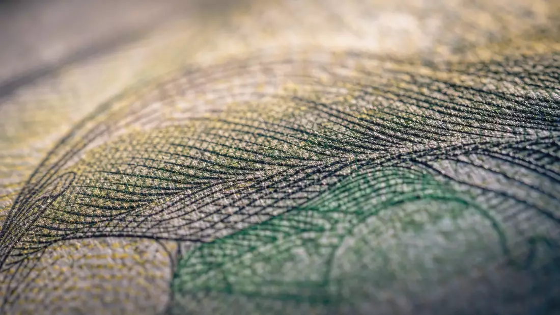 Extreme Nahaufnahme von Banknotenpapier mit feinen Linienmustern und Fasern