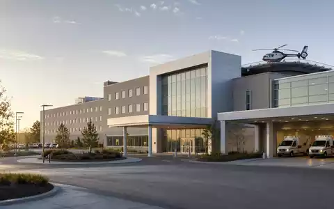 Fotorealistische Klinikfassade mit Rettungswagen zeigt Universal Health, Aktie ISIN US9139031002, moderne Gesundheitsversorgung dargestellt - Foto: THN