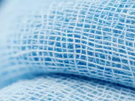 Makroaufnahme von sterilem Verbandsmaterial zeigt Universal Health, Aktie ISIN US9139031002, feine Fasertextur blauer Gaze - Foto: THN