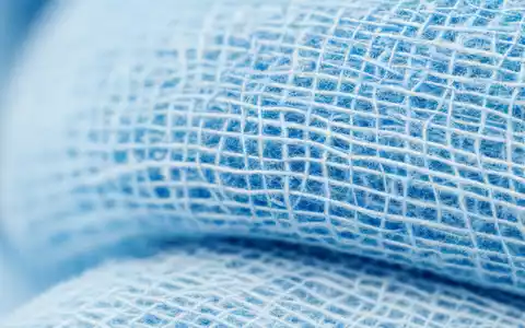 Makroaufnahme von sterilem Verbandsmaterial zeigt Universal Health, Aktie ISIN US9139031002, feine Fasertextur blauer Gaze - Foto: THN