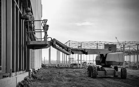 United Rentals Inc. (US9113631090) vermietet Hebebühnen, hier dokumentiert ein Arbeiter auf unbedrucktem Gerät an Baustelle - Foto: THN