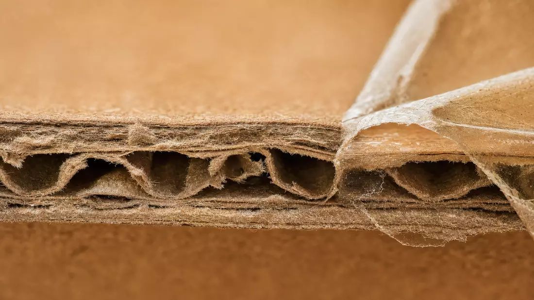 Extreme Nahaufnahme von Wellpappstruktur mit abgelöstem Klebeband
