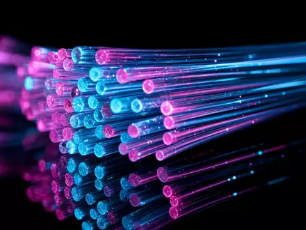 United Internet AG DE0005089031 fokussiert Makroaufnahme leuchtender Glasfaserstränge in Cyan und Magenta als Detailmotiv - Foto: THN
