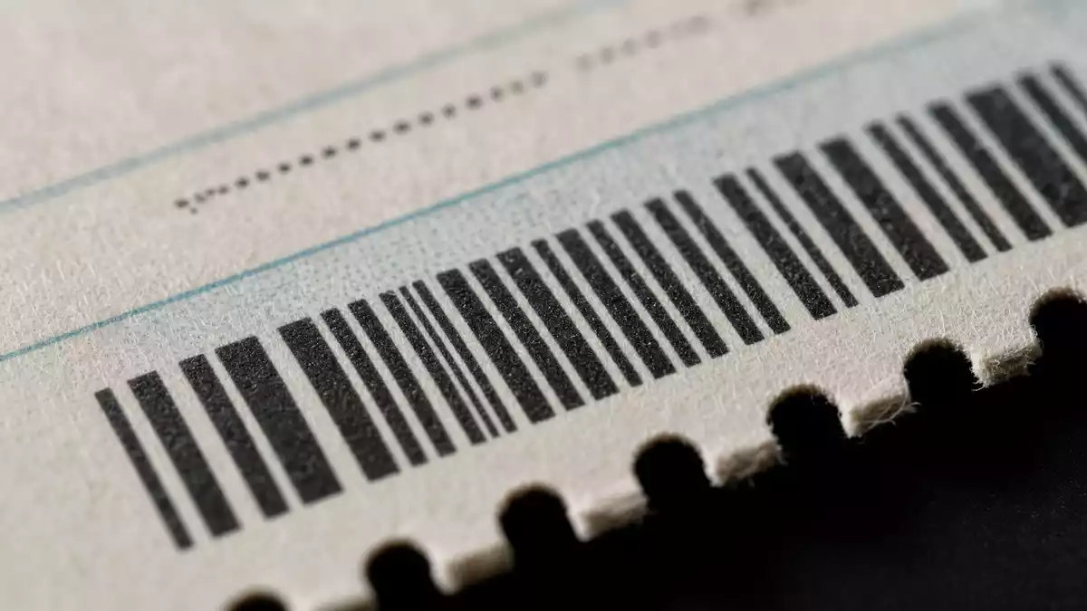 Makrofoto einer Papierfahrkarte mit Barcode und perforiertem Rand