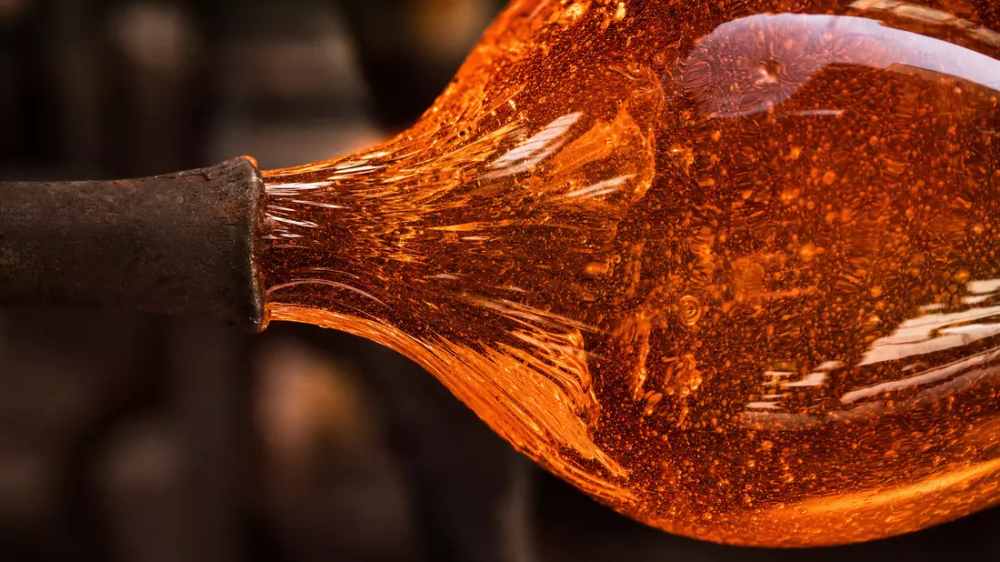Makroaufnahme von orangerot glühendem geschmolzenem Glas mit Blasen