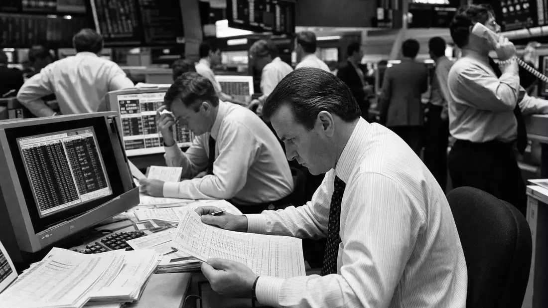 Schwarzweiß-Reportage: Finanzanalyst prüft Post-Trade-Abrechnungsberichte am Börsenparkett