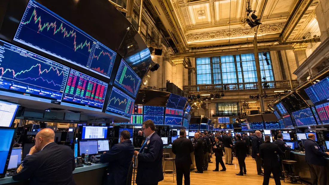 Weitwinkelfoto des NYSE-Handelsparkett mit Händlern und Finanztechnologie-Chartbildschirmen