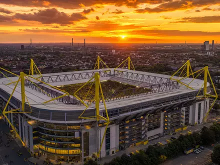 Borussia Dortmund DE0005493092 fotorealistisches Stadionpanorama im Ruhrgebiet bei goldenem Abendlicht aus der Luft - Foto: THN