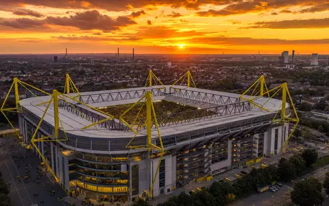 Borussia Dortmund DE0005493092 fotorealistisches Stadionpanorama im Ruhrgebiet bei goldenem Abendlicht aus der Luft - Foto: THN