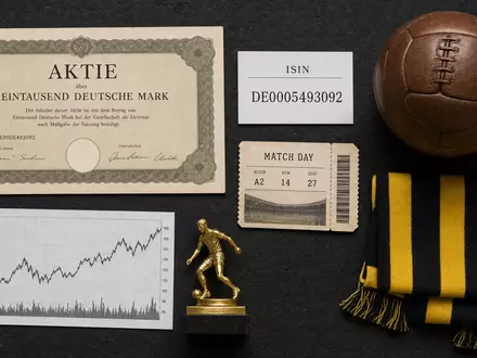 Borussia Dortmund DE0005493092 Flatlay mit Aktienzertifikat ISIN Karte Fußball und gelb schwarzem Schal - Foto: THN