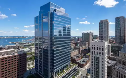 Boston Properties US1011371077 zeigt einen modernen Glasturm im Bostoner Finanzviertel mit Hafenblick - Foto: THN