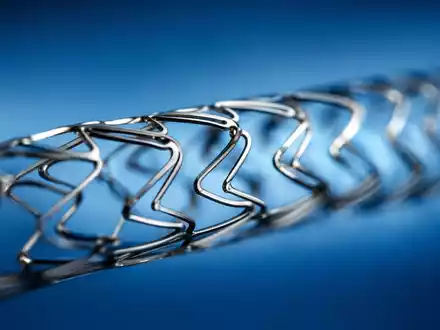 Boston Scientific Corp. Nitinol-Koronarstent in extremer Makroaufnahme mit Gittermuster auf blauem Hintergrund, ISIN US10117L1017 - Foto: THN