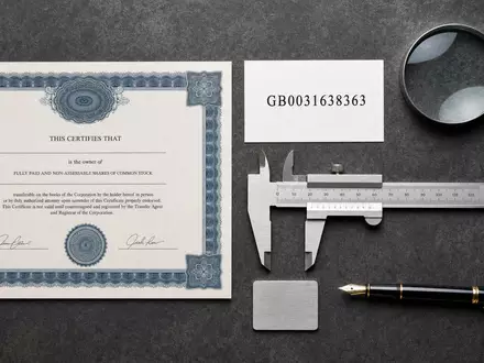 Intertek Group plc GB0031638363 prÀsentiert als Flatlay mit Aktienzertifikat, ISIN-Karte und PrÀzisionsmessinstrumenten auf Schreibtisch - Foto: THN