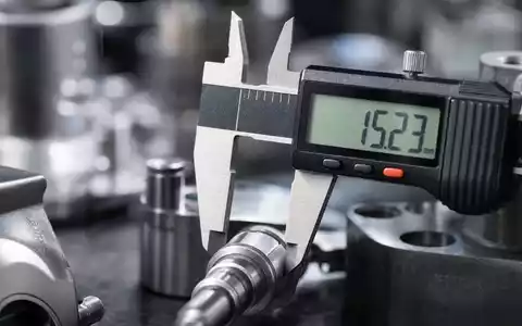 Intertek Group plc GB0031638363 gezeigt in extremer Makroaufnahme eines digitalen Messschiebers an Metallbauteil - Foto: THN