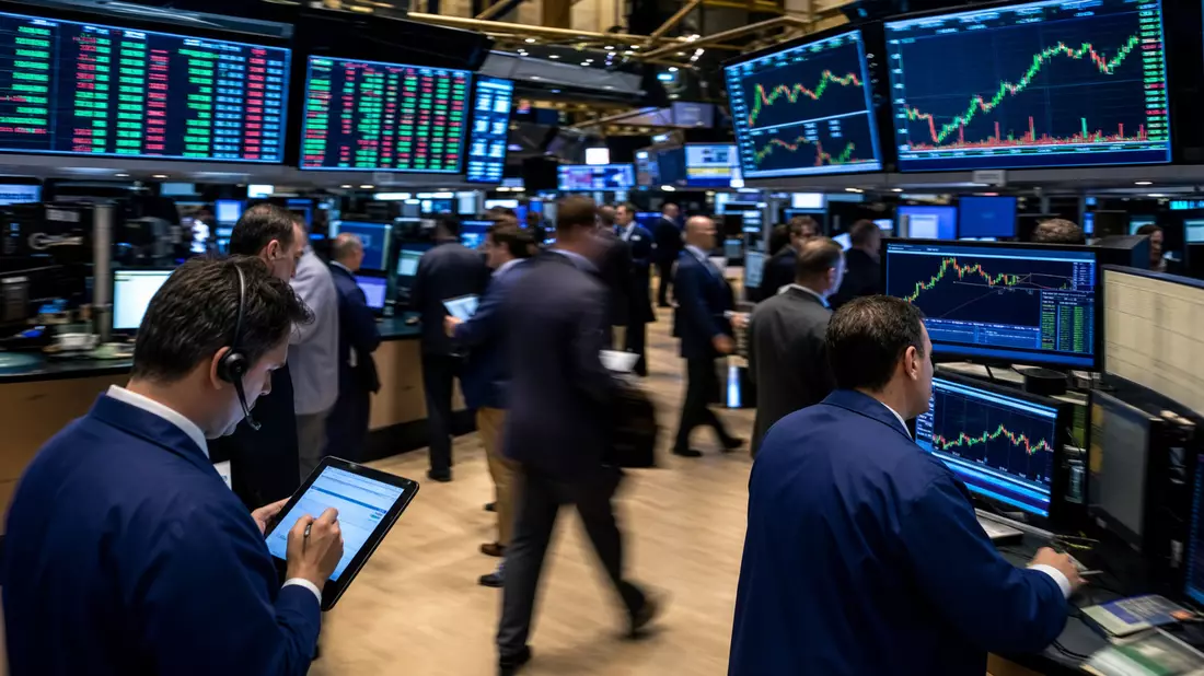 Redaktionelle Fotografie des NYSE-Handelsfloors mit Händlern und grünen Aktiencharts auf Bildschirmen