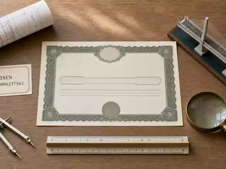 Flatlay mit Aktienzertifikat und ISIN-Karte NL0006237562 sowie klassischen Ingenieurwerkzeugen zum Unternehmen Arcadis N.V - Foto: THN