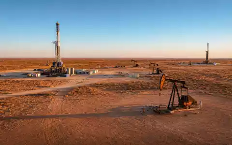 Diamondback Energy Ölfeld US25278X1090 zeigt Pumpjacks und Bohrturm im Permian Basin West Texas - Foto: THN