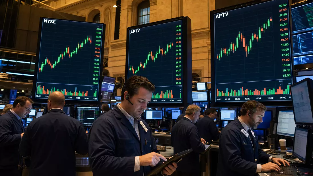 NYSE-Handelsparkett mit Händlern und APTV-Kurscharts auf Monitoren