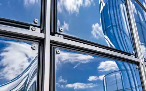 Aroundtown SA LU1673108939 in einer Makro-Detailaufnahme einer blau verspiegelten Glas-Vorhangfassade mit Aluminiumrahmen - Foto: THN