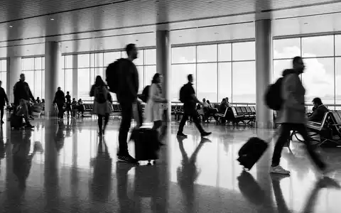 Schwarzweiß-Reportage mit Reisenden im Terminal symbolisiert Flughafen Zürich AG CH0019318550, bedeutenden europäischen Flughafenbetreiber der Verkehrsinfrastruktur - Foto: THN