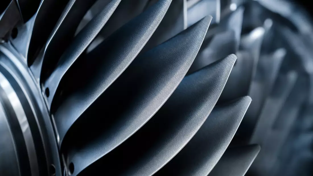 Makrofoto von metallischen Turbinenschaufeln eines Flugzeugtriebwerks in Blautönen