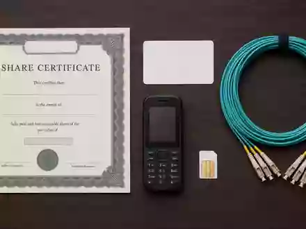 Orange S.A. (FR0000133308) Aktienanlage dargestellt als Flatlay mit Zertifikat, Telefon und Glasfaserkabel - Foto: THN