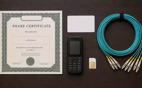 Orange S.A. (FR0000133308) Aktienanlage dargestellt als Flatlay mit Zertifikat, Telefon und Glasfaserkabel - Foto: THN