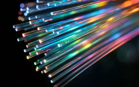 Orange S.A. (FR0000133308) transportiert Daten über Glasfaser, Makroaufnahme zeigt leuchtende bunte Fiberkabel-Enden im Dunkeln - Foto: THN