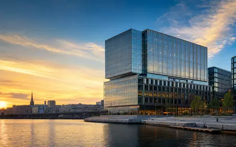 Investor AB (ISIN SE0015811963) symbolisiert durch modernes Stockholmer Bürohochhaus mit gläserner Fassade am Wasser - Foto: THN