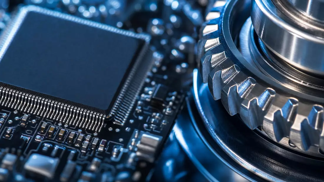 Makroaufnahme eines Computerchips neben glänzendem Metallzahnrad in Blautönen