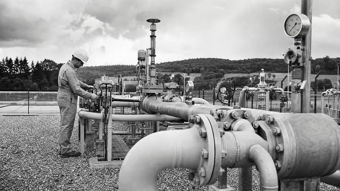 Schwarzweiß-Reportage: Techniker prüft Ventilstation an Erdgas-Pipeline