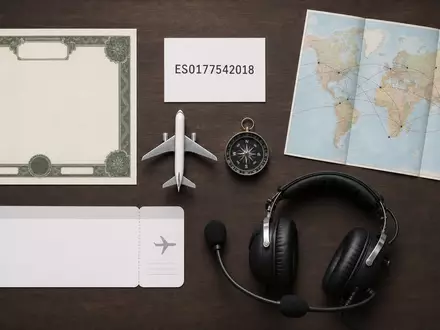 International Consolidated Airlines Group S.A. (ES0177542018): Flatlay zeigt ISIN-Karte, Flugzeugmodell und diverse Luftfahrt-Utensilien - Foto: THN