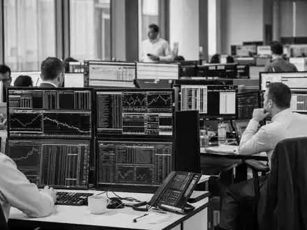 Schwarzweiß-Reportage zeigt Trader an Handelsbildschirmen, symbolisiert Brokerage-Geschäft der FinecoBank S.p.A., ISIN IT0000072170 - Foto: THN