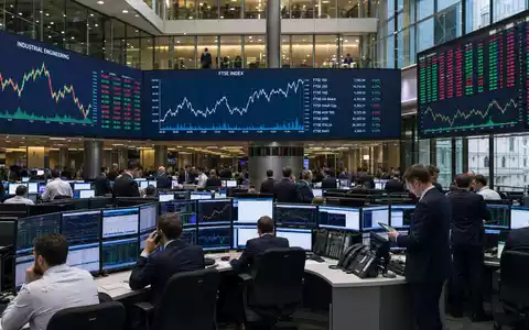 IMI plc GB00B1905F76 zeigt den Börsenhandelssaal in London mit Industrietechnik-Charts und aktuellem FTSE-Index - Foto: THN