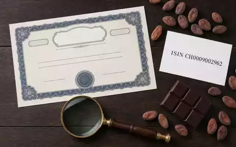 Barry Callebaut AG (CH0009002962) als Flatlay-Komposition mit Aktienzertifikat, ISIN-Karte und branchentypischen Objekten von oben fotografiert - Foto: THN