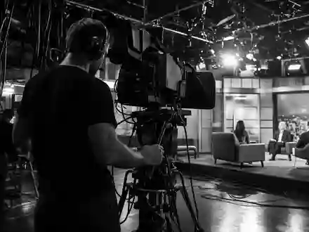 ITV plc GB0033986497 schwarzweiße Reportage zeigt Kameramann bei Live-Übertragung mit dramatischer Hochkontrast-Dokumentarfotografie im Studio - Foto: THN
