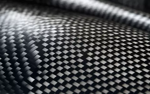 QinetiQ Group plc (ISIN GB00B0WMWD03) nutzt fortschrittliche Verbundwerkstoffe, hier als Makroaufnahme einer Kohlefaserstruktur gezeigt - Foto: THN