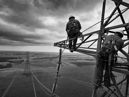 FirstEnergy Corp. zeigt Leitungsmonteure hoch auf einem Stahlmast im Reportage Stil ISIN US3377381088 - Foto: THN