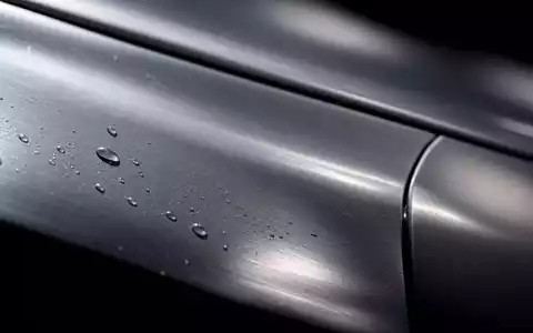 Ford Motor Co. US3453708600 Makroaufnahme einer polierten Stahlkarosserie mit Wassertropfen und Lichtreflexen - Foto: THN